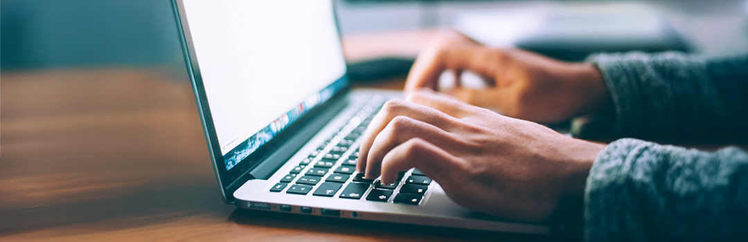 Hände schreiben auf einem Notebook