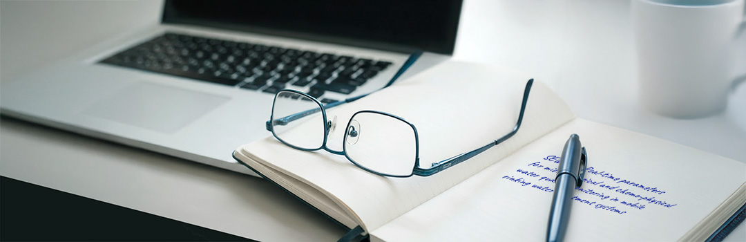 Schreibtisch mit Notebook und Notizen